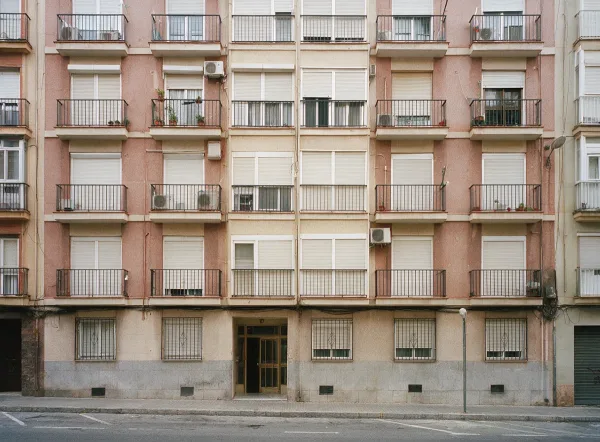 Fachada de bloque de viviendas con balcones y persianas